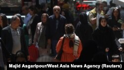 Iranians walk on a street amid the implementation of the new hijab surveillance in Tehran, Iran, April 15, 2023. Even though women can be arrested if they are not wearing a hijab in public, some are seen not wearing head coverings as they move about the community. (Majid Asgaripour/West Asia News Agency via Reuters)