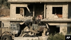 FILE - Israeli forces remove a body of a man killed during a military operation in the West Bank town of Qabatiya, June 13, 2024.