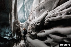 Kings Bay AS airport manager Vegard Sand, 39, looks at the ice walls inside a glacier cave close to Kongsfjord, near Ny-Aalesund, Svalbard, April 8, 2023.