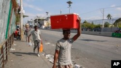 People walk along a street in Port-au-Prince, Haiti, March 13, 2024.