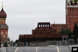 Two servicemen stand on a side roof of the Lenin mausoleum closed for security reasons, in Moscow's Red Square, June 24, 2023