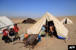 Afghan children stand outside their makeshift tents in an earthquake-affected area of Injil district in Herat province on Oct. 15, 2023.