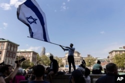 FILE - Columbia University sophomore David Lederer waves the Israeli flag outside the student protest encampment on the campus, April 29, 2024, in New York.