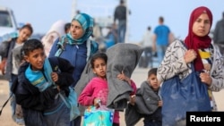 Para pengungsi Palestina berusaha untuk kembali ke rumah mereka di Gaza utara melalui pos pemeriksaan Israel, di tengah konflik antara Israel dan Hamas, seperti yang terlihat dari Jalur Gaza tengah hari Senin, 15 April 2024.