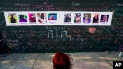 Seorang warga mengunjungi monumen peringatan para korban penembakan di supermaket di Buffalo, pada 19 Mei 2022. (Foto: AP/Matt Rourke)