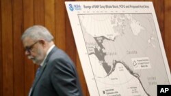 FILE - Federal Administrative Law Judge George Jordan steps past a display before a hearing in Seattle, to help determine whether a small American Indian tribe can once again hunt whales, Nov. 14, 2019. 