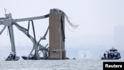 Emergency boats work near the collapsed section of the Francis Scott Key Bridge, after the Dali cargo vessel crashed into it, in Baltimore, March 27, 2024. 