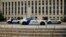 Police cars sit in front of the federal courthouse in Washington, where former president Donald Trump is expected to answer charges after a grand jury returned an indictment for efforts to overturn his 2020 election defeat, Aug. 2, 2023.