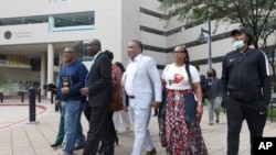 FILE - Attorney Ben Crump, second from left, walks with Ron Lacks, left, Alfred Lacks Carter, third from left, both grandsons of Henrietta Lacks, and other descendants of Lacks, outside the federal courthouse in Baltimore, Oct. 4, 2021. 