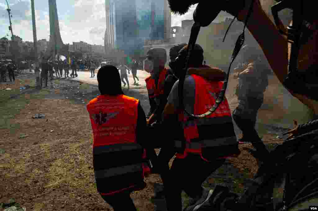 Health workers take a young Palestinian protester to the hospital after he was shot in the leg with live ammunition by Israeli soldiers In Ramallah, Oct. 20, 2023. (Yan Boechat/VOA)