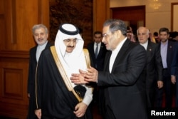 Sekretaris Dewan Keamanan Nasional Tertinggi Iran Ali Shamkhani berbincang dengan Menteri Negara dan Penasihat Keamanan Nasional Arab Saudi Musaad bin Mohammed Al Aiban dalam pertemuan di Beijing, China, 10 Maret 2023. (cnsphoto via REUTERS)