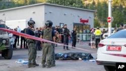 Polisi Israel berdiri di samping jenazah penyerang Palestina yang ditembak tewas di lokasi serangan penembakan di dekat pemukiman Israel "Eli" di Tepi Barat Selasa 20 Juni 2023.