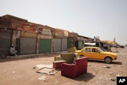 A man sits by shuttered shops in Khartoum, Sudan, April 17, 2023.