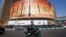 A man rides a motorbike past a billboard depicting Iranian ballistic missiles in service in Tehran on April 19, 2024. 