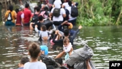 Para migran mencoba masuk wilayah AS melalui sungai Rio Grande dari kota Matamoros, Meksiko. Lonjakan migran diperkirakan terjadi di perbatasan AS-Meksiko karena pemerintahan Biden secara resmi mengakhiri penggunaan aturan pembatasan COVID-19 yang dikenal sebagai "Title 42".(AFP)