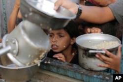 Palestinski dečak čeka na svoju porciu hrane pred verski praznik u Jerusalimu, 15. una 2024.