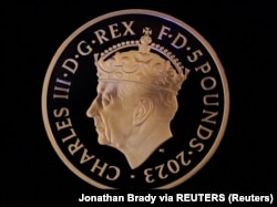 Koin Coronation £5 pertama, di Kastil Windsor, Berkshire. (Foto: Jonathan Brady via REUTERS)
