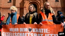 Activists of the environmental group "Last Generation" (Letzte Generation) line up for a march outside the Saint Thomas Church in Berlin's Kreuzberg district, Germany, Apr. 26, 2023.