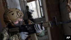 A woman practices combat skills in urban areas during a training course for national resistance of the Municipal Guard, near Kyiv, Ukraine, on Jan. 19, 2024.