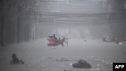Tim penyelamat mendayung perahu untuk mengevakuasi warga di sepanjang jalan yang terendam banjir di Manila, Filipina akibat hujan lebat yang dibawa oleh Topan Gaemi, Kamis (24/7). 