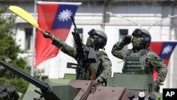 FILE - Taiwanese soldiers salute during National Day celebrations in front of the Presidential Building in Taipei on Oct. 10, 2021.