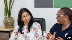 Britain's Home Secretary Suella Braverman, listens to Rwanda's Minister of Education Valentine Uwamariya, during a visit to Kepler University in Kigali, Rwanda, March 19, 2023.