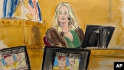 Stormy Daniels testifies on the witness stand as a promotional image for one of her shows featuring an image of former U.S. President Donald Trump is displayed on monitors in Manhattan criminal court in New York, May 9, 2024.