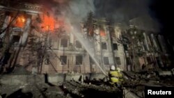 Firefighters work at a site of a building damaged by a Russian missile strike, amid Russia's attack on Ukraine, in Mykolaiv, Ukraine, in this screengrab taken from a handout video released on April 27, 2023.