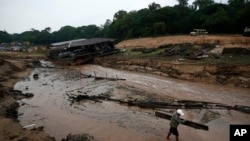 FILE - A resident carries wood to help dam up the Negro River river near his houseboat, in Manaus, Amazonas state, Brazil, Oct. 16, 2023. Human-induced global warming was the primary driver of last year's severe drought in the Amazon, researchers said Jan. 24, 2024. 
