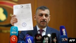 FILE - Haider Hanoun, kepala Komisi Integritas Irak menunjukkan sebuah dokumen terkait kasus yang tengah diselidiki komisi tersebut dalam konferensi pers di Baghdad, pada 22 Juni 2023. (Foto: AFP/Ahmad Al-Rubaye)