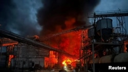 Xilasedicilər Ukraynanın Poltava vilayətində Rusiyanın raket zərbəsi nəticəsində dağılmış məişət yağları zavodunda hadisə yerində işləyirlər, 28 avqust, 2023. 