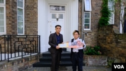 “29原则”执行总监叶七轮(Chakra Ip，右)代表85个人权组织将联署信递交老挝驻英国大使馆职员。（美国之音/郑乐捷）