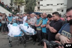 Para pelayat, sebagian besar jurnalis, menghadiri pemakaman rekan mereka, Said al-Taweel dan Mohammed Sobboh yang tewas akibat serangan udara Israel di Kota Gaza pada 10 Oktober 2023.