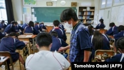 Seorang guru sedang berbincang dengan salah seorang murid di sebuah kelas di Tokyo, 22 November 2022. (Foto: Kazuhiro Nogi/AFP)