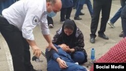 مامور اورژانس در حال کمک به یک دانش آموز دختر. مسمومیت مدارس دخترانه بعد از عید دوباره شروع شد