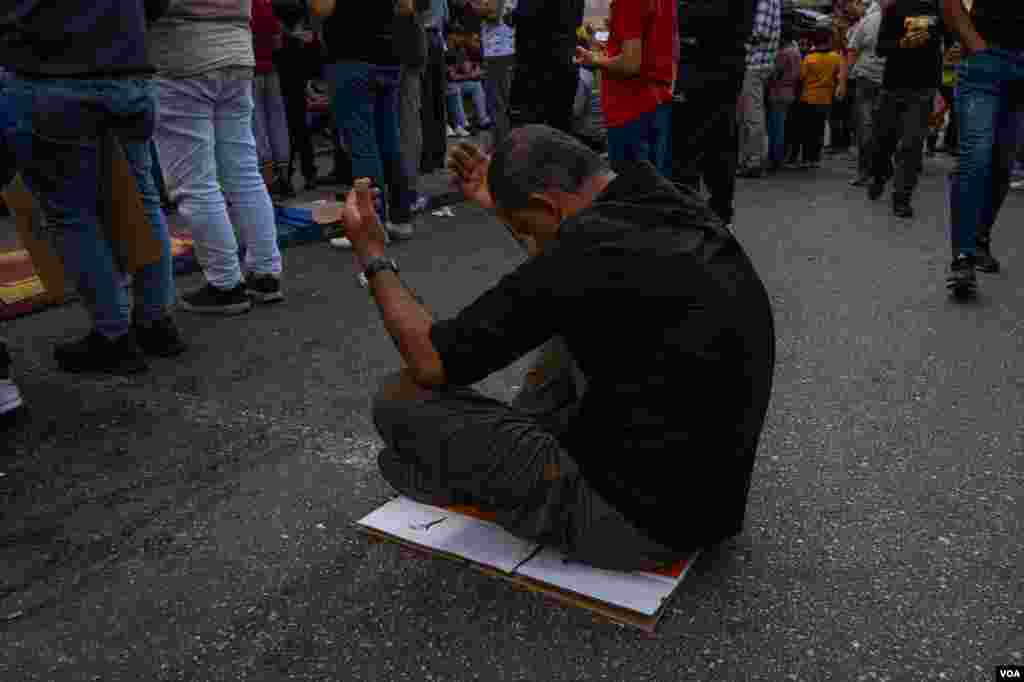A Palestinian man prays outside the main Mosque of Ramallah during the noon Friday prayers, Oct. 20, 2023. (Yan Boechat/VOA)