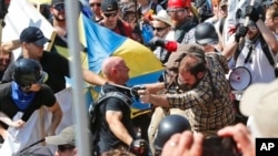 FILE - White nationalists clash with counterdemonstrators at the entrance to Lee Park in Charlottesville, Va., Aug. 12, 2017. Robert Rundo, leader of a Southern California white supremacist group, was among those arrested in connection with the incident.