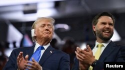 রিপাবলিকান দলের প্রেসিডেন্ট পদের জন্য মনোনীত প্রার্থী ও যুক্তরাষ্ট্রের সাবেক প্রেসিডেন্ট ডনাল্ড ট্রাম্প ভাইস প্রেসিডেন্ট হিসেবে তার পছন্দের ব্যক্তি জে ডি ভ্যান্সের সঙ্গে করতালি দিচ্ছেন। রিপাবলিকান জাতীয় কনভেশনে। ফিসার্ভ ফোরাম, মিলওয়াকি। ফটোঃ ১৫ জুলাই, ২০২৪। 