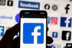 FILE - The Facebook logo is seen on a cell phone, Oct. 14, 2022, in Boston.