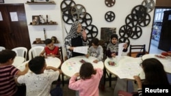 FILE - Children, who were displaced from border villages due to cross-border hostilities between Hezbollah and Israeli forces, color drawings at a center in Tyre, southern Lebanon, April 9, 2024.