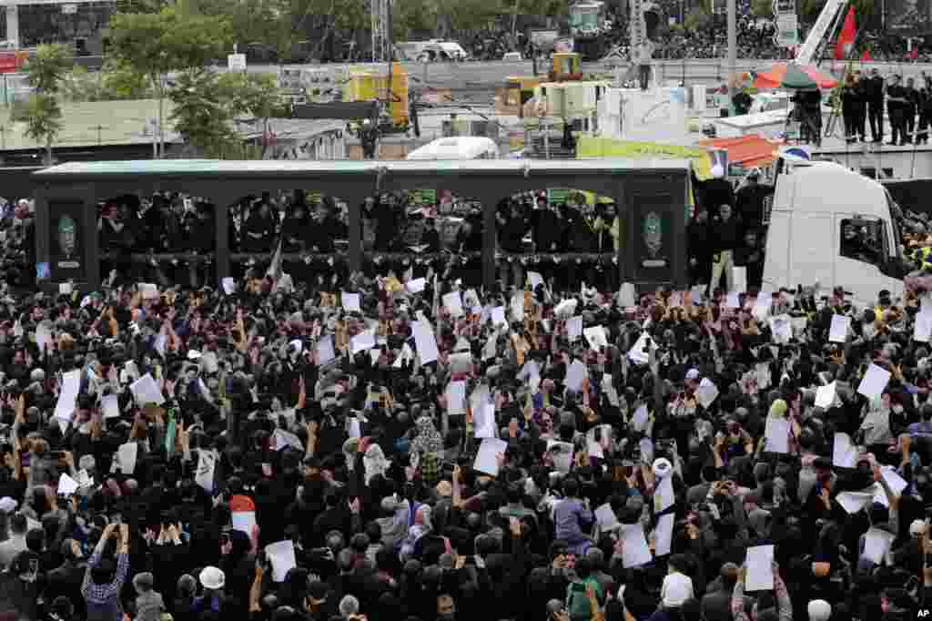 Mourners surround a truck carrying the flag-draped coffins of the President Ebrahim Raisi, and his companions who were killed in a helicopter crash on Sunday, during their funeral ceremony in the city of Mashhad, Iran, May 23, 2024. 