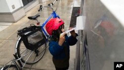 21일 미국 대선 예비선거가 열린 오리건주에서 한 어린이가 우편투표 용지를 수거함에 넣고 있다.