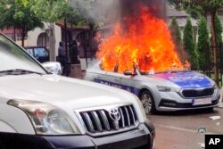 FILE - In this image made from video, a Kosovar police car burns in Zvecan, Kosovo, on May 26, 2023. A series of violent clashes near the Serbia-Kosovo border fueled fears of a return to open conflict.