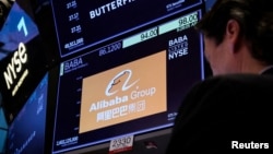 A trader works at the post where Alibaba is traded on the floor of the New York Stock Exchange in New York, March 28, 2023.