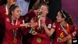 นักฟุตบอลหญิงทีมชาติสเปน โอลกา คาร์โมนา (ซ้าย) เอวา นาวาร์โร (กลาง) และ ไอตานา บอนมาตี (ขวา) ร่วมยินดีกับถ้วยแชมป์ฟุตบอลโลกหญิง 2023 (ภาพจากเอพี)