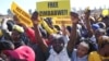 FILE - Supporters of Zimbabwe's main opposition leader Nelson Chamisa hold placards upon his arrival for a a rally on the outskirts of Harare on July 17, 2023.