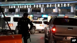 A US Customs and Border Protection official stands among the lanes of cars entering the San Ysidro Port of Entry on May 11, 2023, in Tijuana, Mexico.