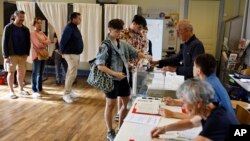 A woman casts her ballot in the second round of the legislative elections, in Rennes, western France, July 7, 2024.