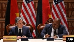 Menteri Luar Negeri AS Antony Blinken (kiri) dan Menteri Pertahanan Papua Nugini Win Bakri Daki (kanan) menandatangani perjanjian keamanan di Forum Kerjasama India-Kepulauan Pasifik di APEC Haus di Port Moresby, 22 Mei 2023. (ADEK BERRY / AFP)