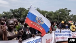 Seorang demonstran memegang bendera Rusia dalam aksi menunjukkan dukungan terhadap keberadaan Rusia dan China di Republik Afrika Tengah, di ibu kota Bangui, pada 22 Maret 2023. (AFP/Barbara Debout)